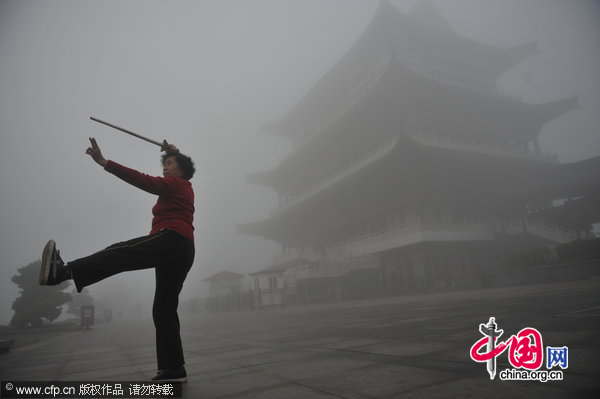 A woman is doing morning exerice in dense fog in Changsha, Southeast China&apos;s Jiangsu province on the morning of Dec 1, 2010. [CFP]