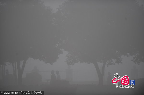 People walk on the road in dense fog in Changsha, Southeast China&apos;s Jiangsu province on the morning of Dec 1, 2010. [CFP]