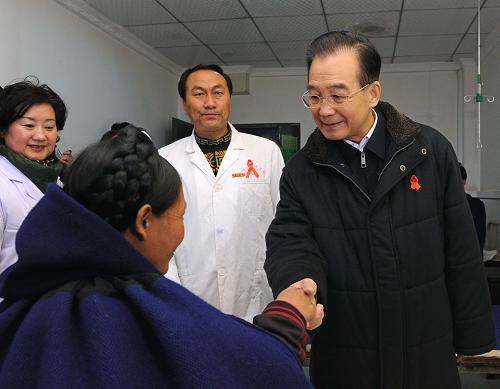 Chinese Premier Wen Jiabao (R front) shakes hands with an AIDS patient in Liangshan Yi Autonomous Prefecture, southwest China&apos;s Sichuan Province, Dec. 1, 2010. Visiting poverty-stricken area, Wen urged a better incorporation of AIDS control work with economic development in less developed areas. [Xinhua]