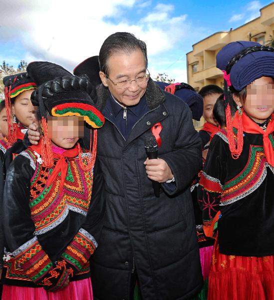 Chinese Premier Wen Jiabao (C) visits the orphans whose parents died of AIDS at a primary school in Sikai Town, Zhaojue County of Liangshan Yi Autonomous Prefecture, southwest China&apos;s Sichuan Province, Dec.1, 2010. Visiting poverty-stricken area, Wen urged a better incorporation of AIDS control work with economic development in less developed areas. [Xinhua]