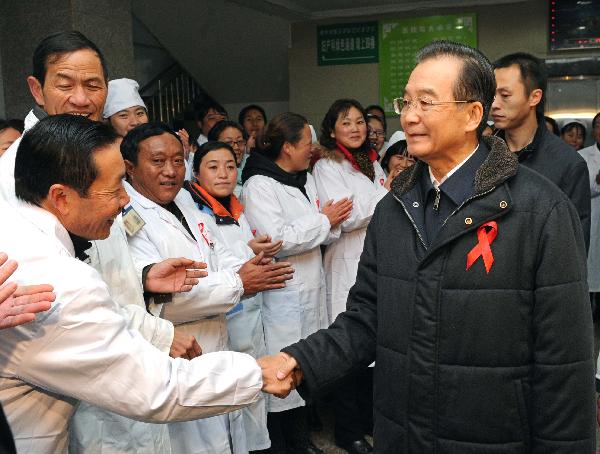 Chinese Premier Wen Jiabao (1st R front) shakes hands with medical personnel as he visits the AIDS treatment center of People&apos;s Hospital in Zhaojue County of Liangshan Yi Autonomous Prefecture, southwest China&apos;s Sichuan Province, Dec.1, 2010. Visiting poverty-stricken area, Wen urged a better incorporation of AIDS control work with economic development in less developed areas. [Xinhua]