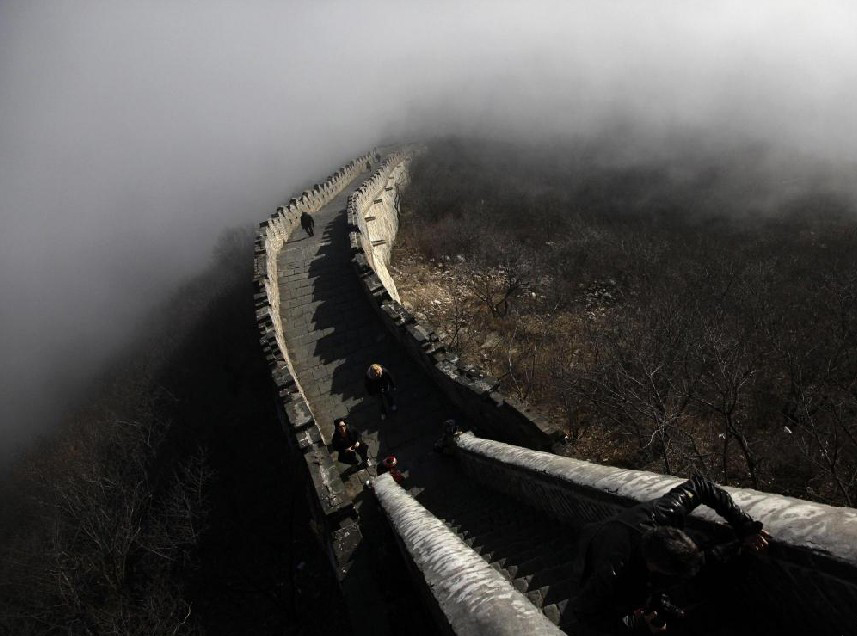 Tourists walk along a section of the Great Wall shrouded in mist at Simatai, located in the outskirts of Beijing December 1, 2010. [China Daily]