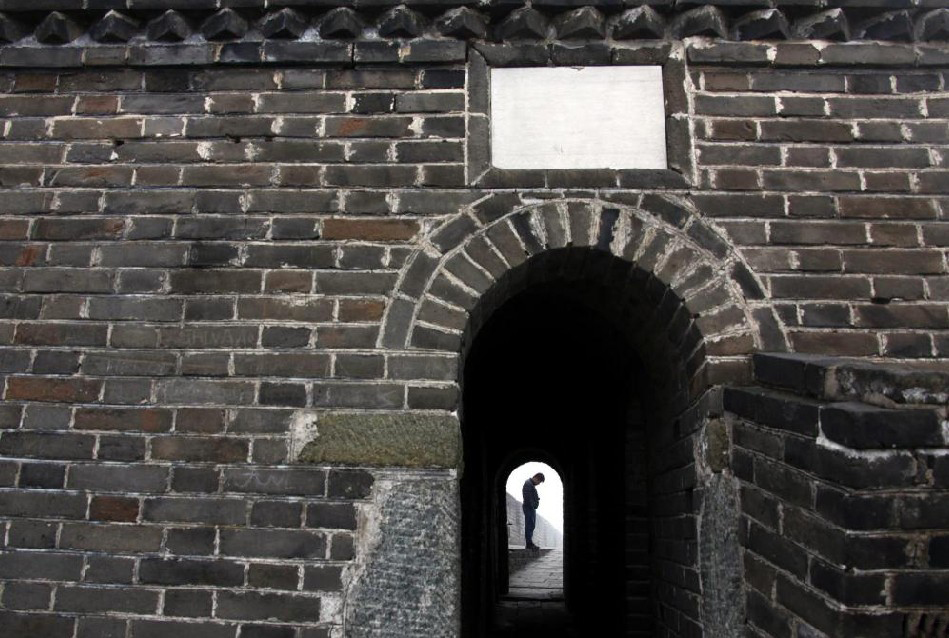 A tourist is seen through the archway of a watchtower standing on the Great Wall at Simatai, located in the outskirts of Beijing December 1, 2010. [China Daily] 