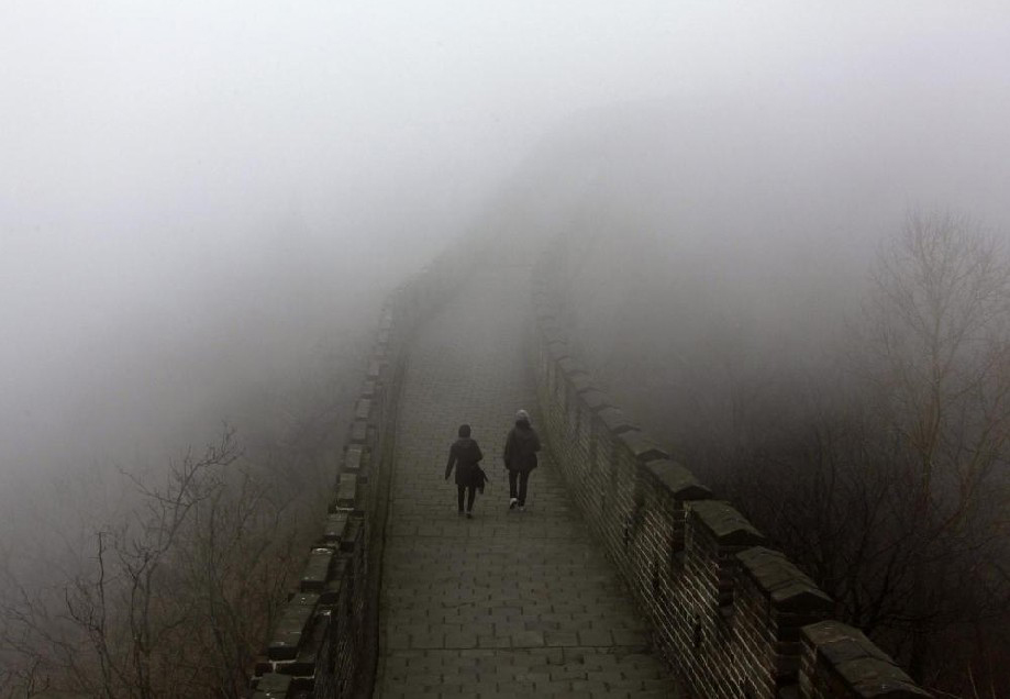 Tourists walk along a section of the Great Wall shrouded in mist at Simatai, located in the outskirts of Beijing December 1, 2010. [China Daily]