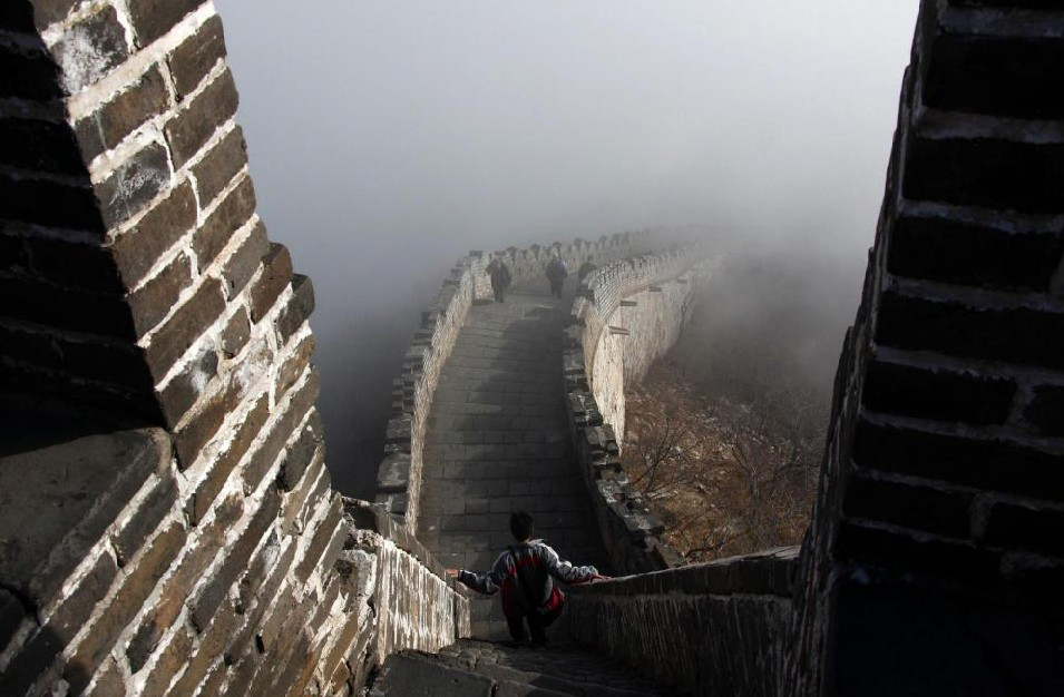 Tourists walk along a section of the Great Wall shrouded in mist at Simatai, located in the outskirts of Beijing December 1, 2010. [China Daily]