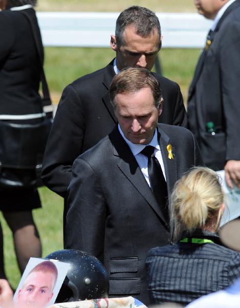 New Zealand Prime Minister John Key (C) walks by a table holding memorabilia from miners during a memorial service in South Island West Bank town of Greymouth on Dec. 2, 2010, for the 29 miners and contractors who lost their lives in the Pike River coal mine explosions which began on Nov. 19. [Xinhua]