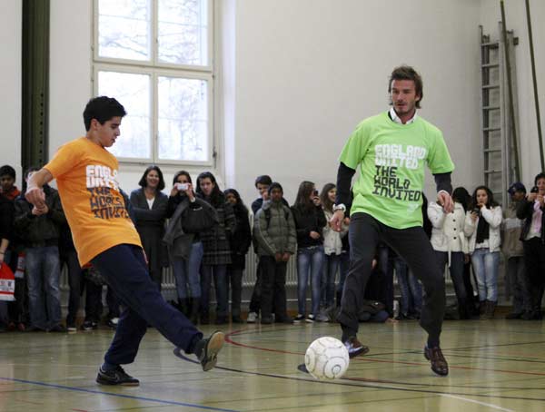 Soccer player David Beckham, a key ambassador to England's bid to stage the 2018 FIFA World Cup, plays soccer with school children during a visit to a school, ahead of the 2018 and 2022 FIFA World Cup host announcement in Zurich November 30, 2010. England, Russia, Spain/Portugal and Belgium/Netherlands are bidding for 2018 with United States, Japan, Australia, South Korea and Qatar the candidates for 2022. (Xinhua/Reuters Photo)