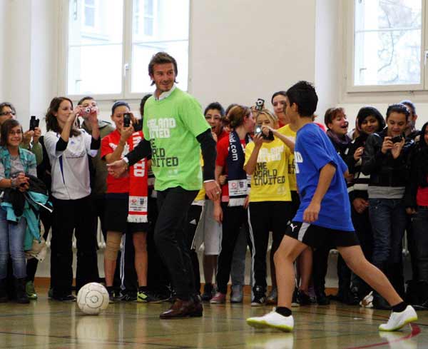 Soccer player David Beckham, a key ambassador to England's bid to stage the 2018 FIFA World Cup, plays soccer with school children during a visit to a school, ahead of the 2018 and 2022 FIFA World Cup host announcement in Zurich November 30, 2010. (Xinhua/Reuters Photo)