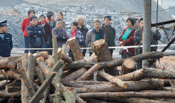 People gather near a flooded coal mine where seven miners were trapped underground in Xiangtan county of Hunan province, Dec 1, 2010. [Photo/Xinhua] 