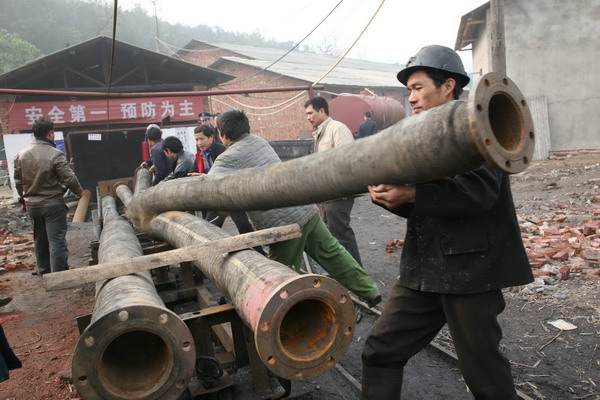 Rescuers transport pipes on Wednesday for pumping out water from a flooded coal mine in Xiangtan county of Hunan province. [Photo/China News Service]