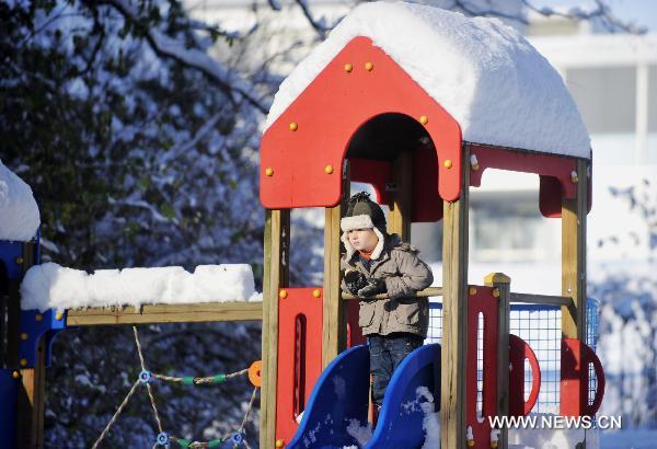 A boy plays in the snow in Geneva, Switzerland, Dec. 2, 2010. Weather turned fine in Geneva on Thursday after the continuous snowfall. [Xinhua]