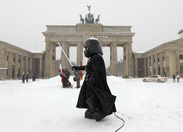 A street performer dressed as the character Darth Vader from the film &apos;Star Wars&apos; stands in front of the Brandenburg Gate during snowfall in Berlin, December 2, 2010. Heavy snowfalls over the past hours caused serious traffic jams and numerous minor traffic accidents all over Germany on Thursday. Air travel in the south of the country was also disrupted, with several flights cancelled.[China Daily/Agencies]