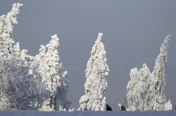 People walk down through the snow near the peak of the Feldberg mountain in Koenigstein, 30km west of Frankfurt, December 2, 2010. [China Daily/Agencies]