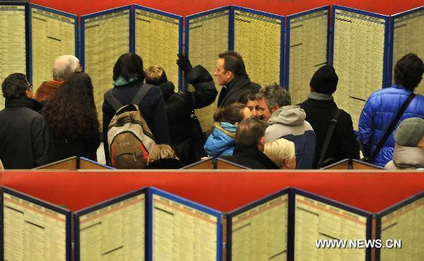 Commuters check the train&apos;s timetable at the Central Station in Brussels, capital of Belgium, Dec. 2, 2010. Affected by heavy snow, more commuters tended to use public transports, especially railway and metro. [Xinhua]