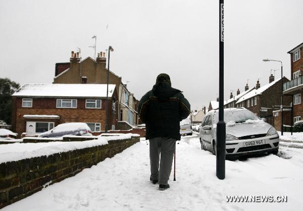 A pedestrian walks on the snow-covered street in southern London, Britain, Dec. 2, 2010. The large-scale snowfall since last week has badly disrupted the transportation system in Britain by hitting airports, roads and railways.[Xinhua]