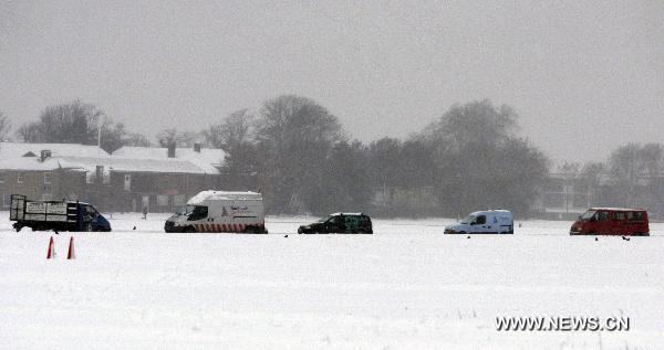 Vehicles run slowly on a snow-covered road in southern London, Britain, Dec. 2, 2010. The large-scale snowfall since last week has badly disrupted the transportation system in Britain by hitting airports, roads and railways. [Xinhua]