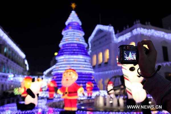 A visitor takes photos of illuminating decorations for the coming Christmas Day during the lighting ceremony in Macao, south China, Dec. 2, 2010. [Xinhua] 