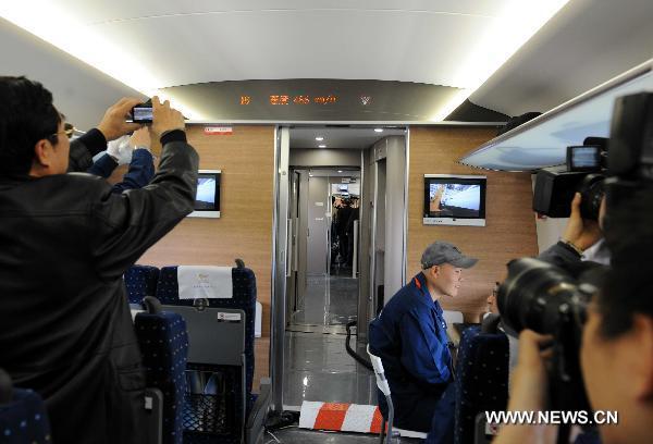 Reporters take photos in the train CRH380A of China Railway High-Speed (CRH), which runs between the north China&apos;s Zaozhuang city and Bengbu in the south, a segment of the Beijing-Shanghai high-speed rail line, Dec. 3, 2010. China&apos;s high-speed train CRH380A hit a maximum speed of 486.1 kilometers per hour on Friday during its trial service, which broke a world operation speed record. [Xinhua]