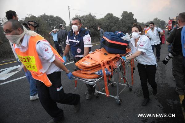 Israeli rescue workers are on their way to deal with a massive forest fire in the Carmel Forest near the Israeli northern city of Haifa Dec. 2, 2010. At least 40 people are dead in what officials describe as a historic 'firestorm' that broke out early Thursday in the Carmel mountain range overlooking the city. [JINI/Xinhua]