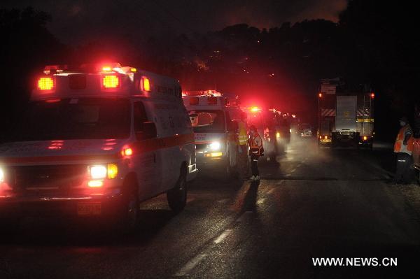 Ambulances park near the Carmel Forest which was hit by a massive fire near the Israeli northern city of Haifa Dec. 2, 2010. At least 40 people are dead in what officials describe as a historic 'firestorm' that broke out early Thursday in the Carmel mountain range overlooking the city. [JINI/Xinhua]