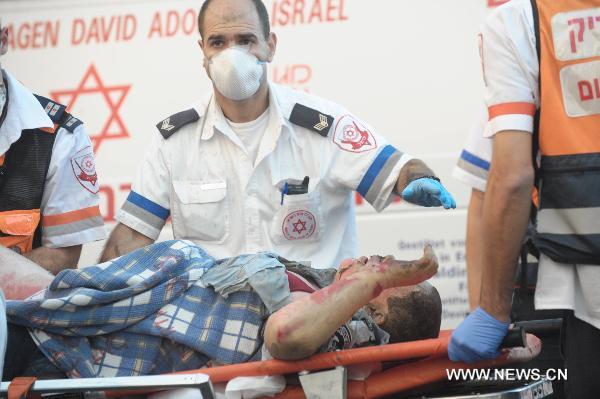 A man injured in a massive forest fire in the Carmel Forest near the Israeli northern city of Haifa is transfered by rescue workers Dec. 2, 2010. At least 40 people are dead in what officials describe as a historic 'firestorm' that broke out early Thursday in the Carmel mountain range overlooking the city. [JINI/Xinhua]