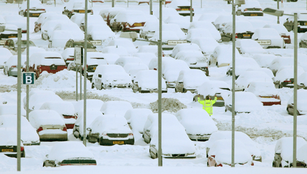 A man waves to a colleague in a car park at Edinburgh Airport, in Edinburgh, Scotland December 2, 2010. More heavy snow caused havoc across Britain on Thursday, keeping Gatwick closed for a second day, disrupting rail services and leaving travellers stranded. [Xinhua]