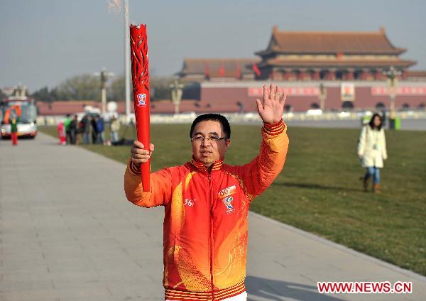 Torch bearer Ren Suyong runs with the torch during the torch relay for Guangzhou 2010 Asian Para Games held at the Tian'anmen Square in Beijing, capital of China, Dec. 4, 2010. [Xinhua/Liu Dawei]