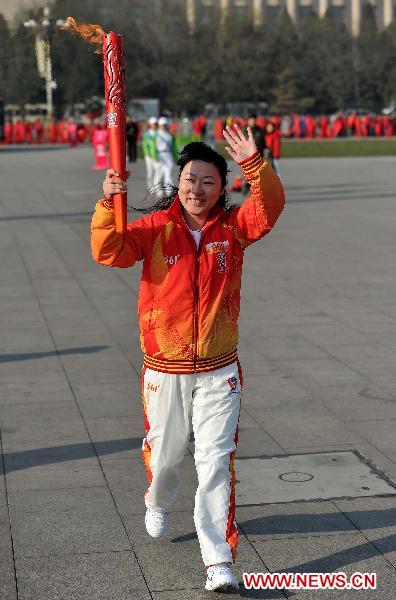 Torch bearer Han Jie runs with the torch during the torch relay for Guangzhou 2010 Asian Para Games held at the Tian'anmen Square in Beijing, capital of China, Dec. 4, 2010. [Xinhua/Liu Dawei]