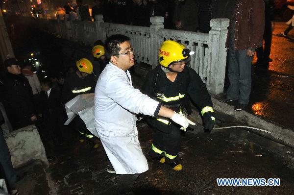 Rescuers and medical staff work on the explosion site of an Internet Cafe in downtown of Kaili City in Miao-Dong Autonomous Prefecture of Qiandongnan, southwest China's Guizhou Province, on early morning of Dec. 5, 2010. Six people were killed and 37 others injured in an explosion that ripped through an Internet cafe at around 10:30 p.m. on Saturday, according to local police. (Xinhua/Chen Peiliang)