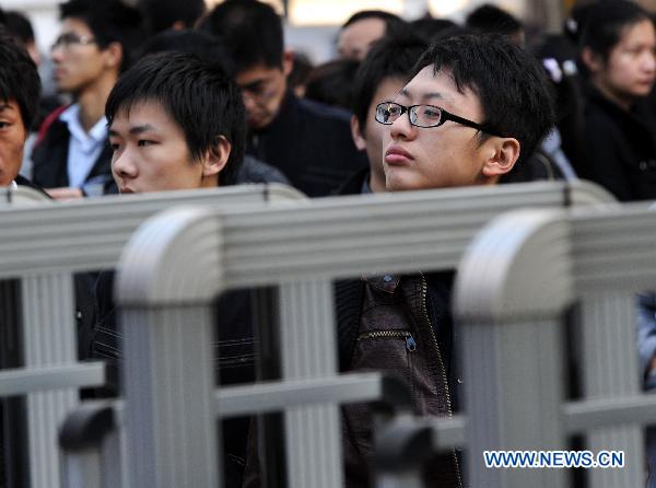 Participants wait to enter the examination site before the first section of the annual national examination to select public servants in Nanjing, capital of east China&apos;s Jiangsu Province, Dec. 5, 2010. Over 1.4 million people across China sit in the country&apos;s national examination on Sunday. [Xinhua]