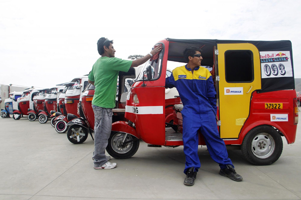 Drivers of three-wheeled taxi vehicles, called &apos;mototaxi&apos;, wait before a race against the clock on the outskirts of Lima, Peru Dec 5, 2010.Ninety-six drivers of three-wheeled taxis participated in a competition for the fastest driver around a 1km (0.62 miles) circuit. [China Daily/Agencies]