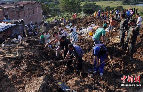 Police and residents dig at the site where a landslide buried dozens of homes in Bello, northwestern Colombia, Dec. 5, 2010. As many as 200 people may have been buried in a landslide Sunday that swept over 10 houses near Medellin, Colombia's second largest city, Red Cross relief workers said. 