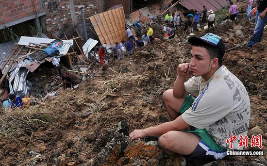 Police and residents dig at the site where a landslide buried dozens of homes in Bello, northwestern Colombia, Dec. 5, 2010. As many as 200 people may have been buried in a landslide Sunday that swept over 10 houses near Medellin, Colombia's second largest city, Red Cross relief workers said. 