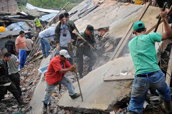 Police and residents dig at the site where a landslide buried dozens of homes in Bello, northwestern Colombia, Dec. 5, 2010. As many as 200 people may have been buried in a landslide Sunday that swept over 10 houses near Medellin, Colombia's second largest city, Red Cross relief workers said. [Xinhua]