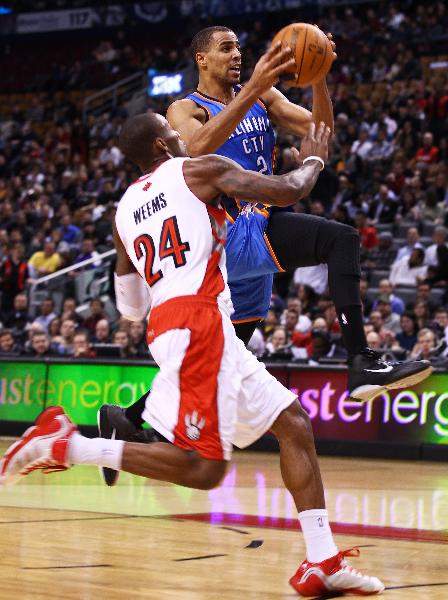 Oklahoma City Thunders' Thabo Sefolosha (R) goes to the basket during the NBA game against Toronto Raptors at Air Canada Centre in Toronto, Canada, Dec. 3, 2010. Raptors won by 111-99. (Xinhua/Zou Zheng)