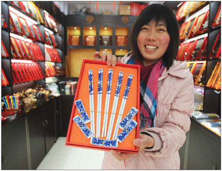 Creative designer Xing Junming shows off a decorative set of  chopsticks. Chinese zodiac animal designs are popular with  European tourists.