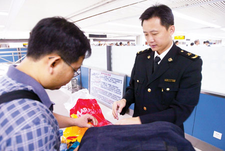 A customs official in Shenzhen, Guangdong Province, checks a traveler's luggage for smuggled goods. Authorities have stepped up measures against smuggling across the Hong Kong border, a practice that costs the country millions in tax revenue.