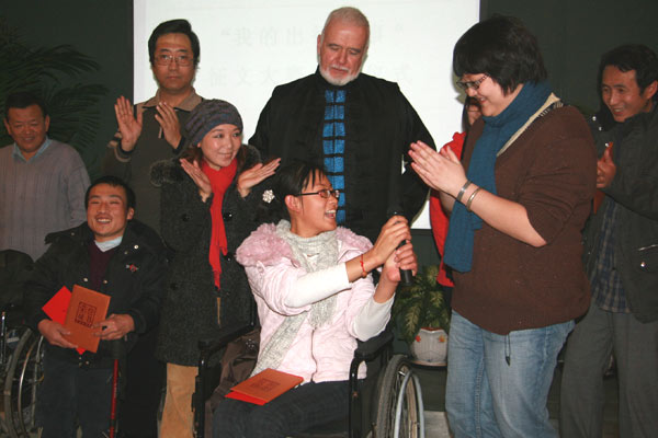 Li Wei (1st R), program director of Enable Disability Studies Institute, presents awards to winners who of a composition competition 'Stories in My Trip,' co-organized by Enable Disability Studies Institute and canjiren.org. 