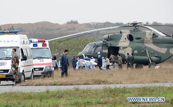 Paramedics transfer an injured man out of a helicopter in Chengdu, southwest China&apos;s Sichuan Province, Dec. 6, 2010. Four injured people in the wild fire in Daofu County have been transfered to the hospitals in Chengdu by helicopters to receive further medical treatment on Monday. [Xinhua]