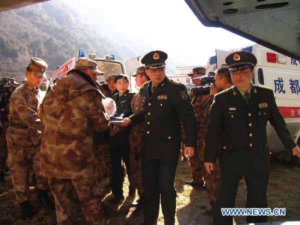 Officers of the People&apos;s Liberation Army help to transfer an injured man onto a helicopter in Kangding, southwest China&apos;s Sichuan Province, Dec. 6, 2010. Four injured people in the wild fire in Daofu County have been transfered to the hospitals in Chengdu by helicopters to receive further medical treatment on Monday. [Xinhua]