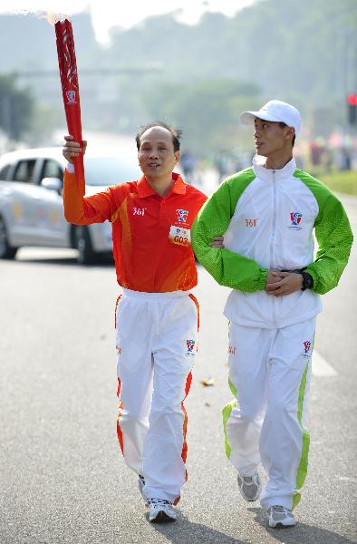 Torchbearer Tan Taosheng relays the torch during the torch relay for the Guangzhou 2010 Asian Para Games in Guangzhou, south China's Guangdong Province, Dec. 6, 2010. (Xinhua/Liang Xu) 