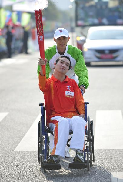 Torchbearer Yan Zhiqiang relays the torch during the torch relay for the Guangzhou 2010 Asian Para Games in Guangzhou, south China's Guangdong Province, Dec. 6, 2010. (Xinhua/Liang Xu) 