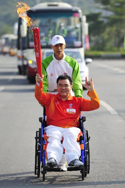 Torchbearer Deng Bingqiang relays the torch during the torch relay for the Guangzhou 2010 Asian Para Games in Guangzhou, south China's Guangdong Province, Dec. 6, 2010. (Xinhua/Liang Xu) 