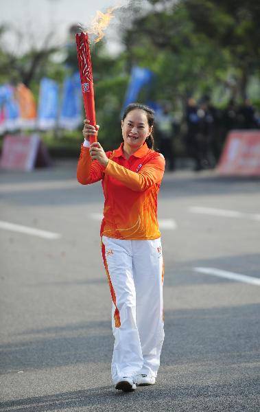 Torchbearer Wang Yanhong relays the torch during the torch relay for the Guangzhou 2010 Asian Para Games in Guangzhou, south China's Guangdong Province, Dec. 6, 2010. (Xinhua/Liang Xu) 