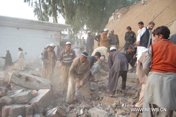 People clear the rubble at the site of a suicide bombing in northwest Pakistan's Mohmand region on December 6, 2010. Two suicide bombers Monday targeted a meeting of pro-government tribal elders in a Pakistani tribal region, killing at least 50 people with 120 others injured. 