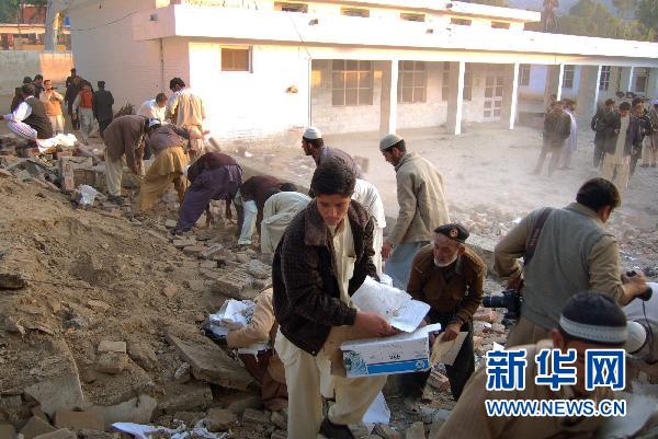 People clear the rubble at the site of a suicide bombing in northwest Pakistan's Mohmand region on December 6, 2010. Two suicide bombers Monday targeted a meeting of pro-government tribal elders in a Pakistani tribal region, killing at least 50 people with 120 others injured.