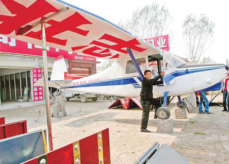 Farmer entrepreneur He Zhuangzhi, from Neihuang county, Henan province, poses with his Haiyan-650c plane in this file photo taken in October 2008. 
