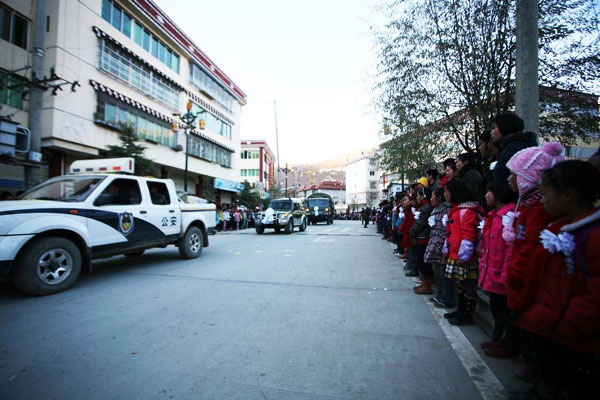 Locals line up along the road to see off the firefighters who gave their lives putting out a wildfire on plateau grassland in Dawu county, Southwest China&apos;s Sichuan province, Dec 6, 2010. [Xinhua] 