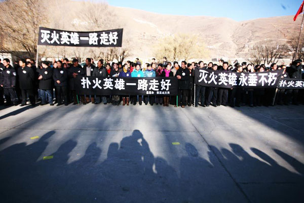 Locals line up along the road to see off the firefighters who gave their lives putting out a wildfire on plateau grassland in Dawu county, Southwest China&apos;s Sichuan province, Dec 6, 2010. [Xinhua]