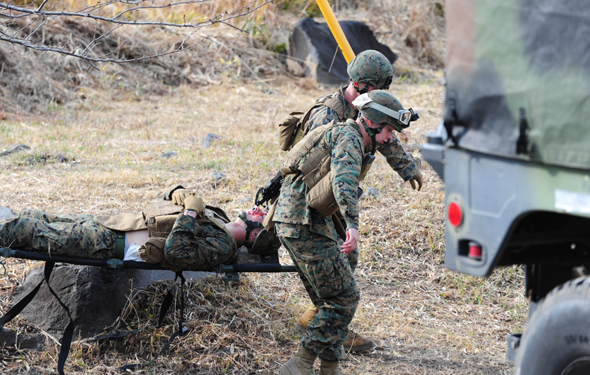 U.S. Marines help mock wounded comrade during ground medical-aid training in Kirishima Training Area in southern Japan&apos;s Miyazaki Prefecture, Dec. 7, 2010. [Xinhua]